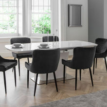 COMO High Gloss White Extendable Dining Table with butterfly extension system, paired with six black quilted chairs in a modern dining room setting.