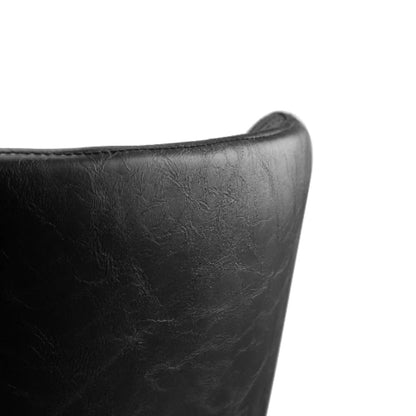 Close-up of the back edge of the Luxe Faux Leather Dining Chair, showing the smooth faux leather finish and curved design.